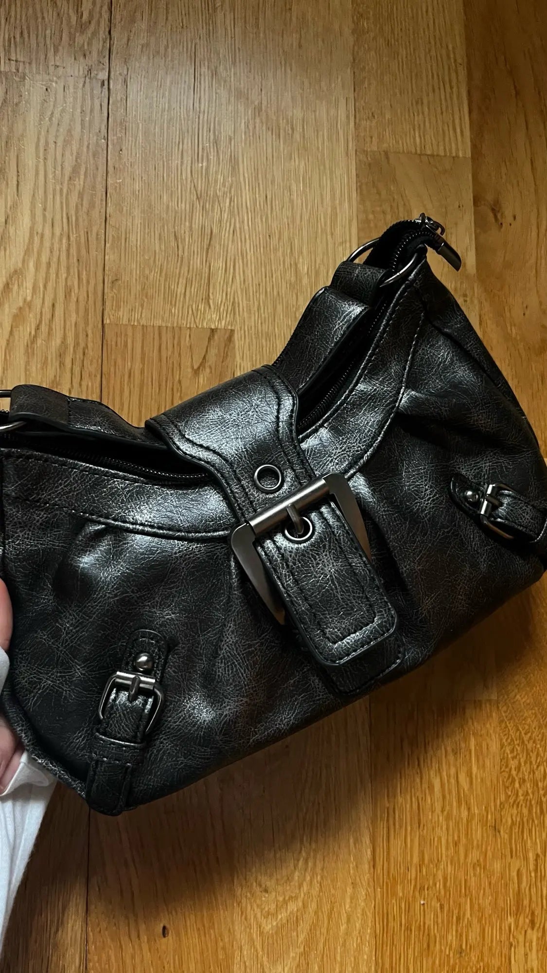 Axelväska dam retro moto med nitar och veckad halvmånform i enfärgad design